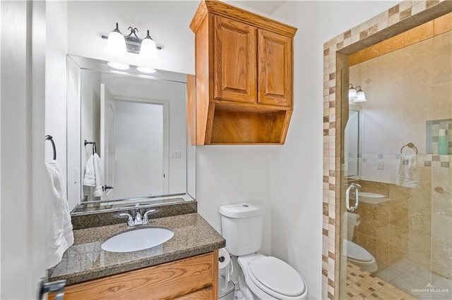 bathroom featuring a stall shower, vanity, and toilet