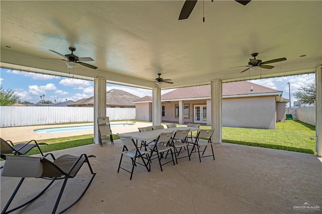 view of patio / terrace featuring french doors, outdoor dining area, a fenced backyard, and a fenced in pool