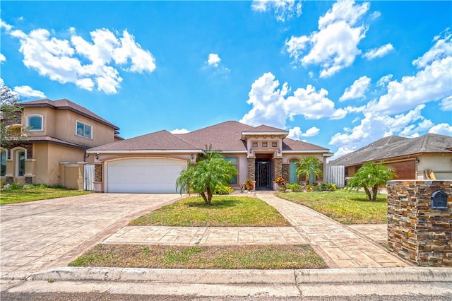 mediterranean / spanish home with a garage, decorative driveway, a front yard, and stucco siding