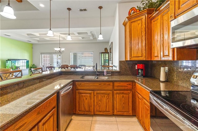 kitchen with visible vents, decorative backsplash, brown cabinetry, appliances with stainless steel finishes, and a sink