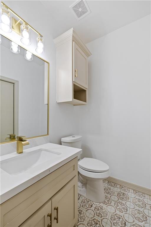 half bath featuring visible vents, toilet, vanity, tile patterned flooring, and baseboards