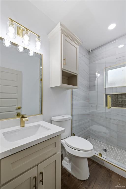 full bath featuring vanity, wood finished floors, toilet, and a shower stall