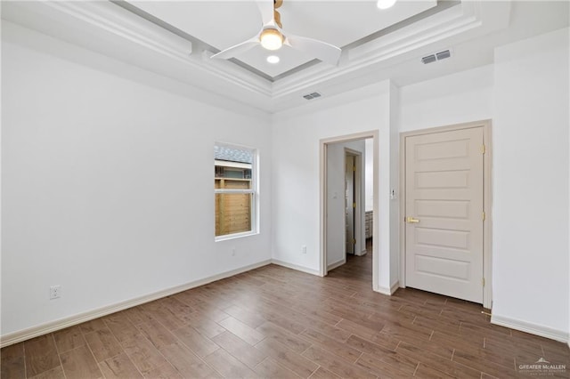 empty room with ceiling fan, wood finished floors, visible vents, and baseboards