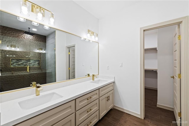 full bath with wood finish floors, a sink, a shower stall, and double vanity