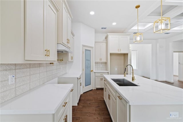 kitchen featuring recessed lighting, dark wood-style flooring, a sink, visible vents, and a center island with sink