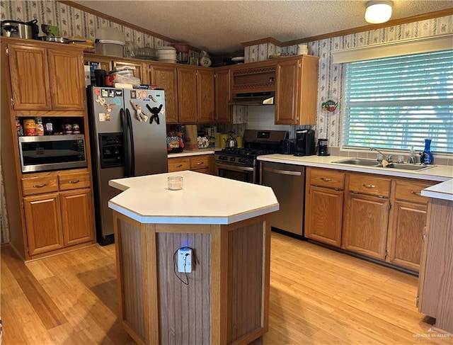 kitchen with sink, stainless steel appliances, extractor fan, light hardwood / wood-style floors, and ornamental molding