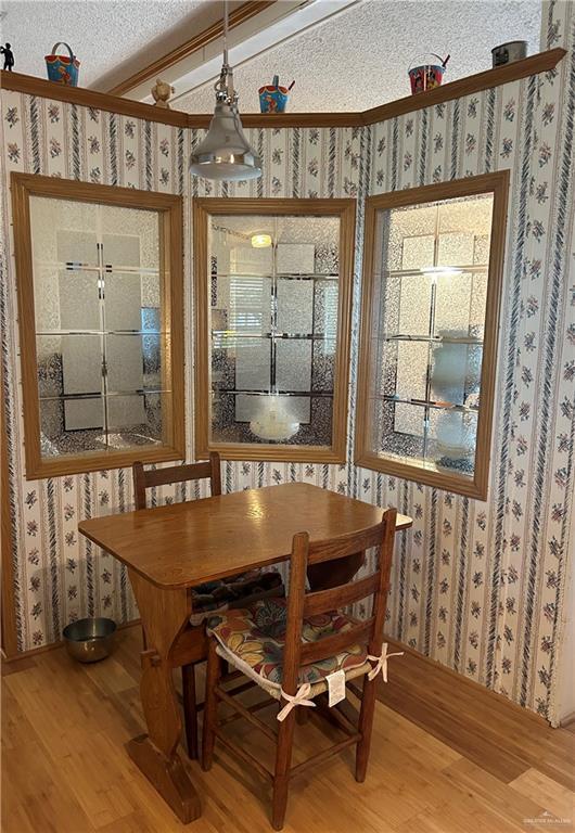 2910 Saltwater Ave, Edinburg, TX 78542 - dining space featuring light wood-style flooring, wallpapered walls, and a textured ceiling