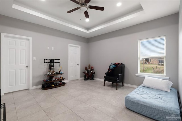 sitting room featuring a tray ceiling, light tile patterned flooring, and baseboards