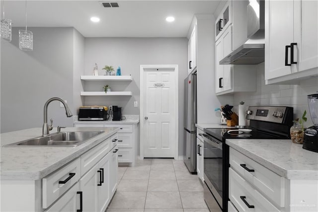 kitchen with open shelves, stainless steel appliances, white cabinets, a sink, and wall chimney range hood