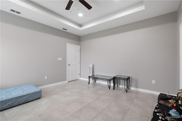 sitting room featuring a tray ceiling, visible vents, and baseboards