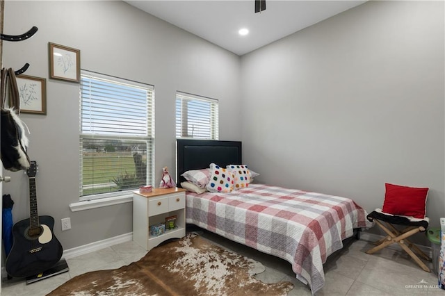 bedroom with light tile patterned floors and baseboards