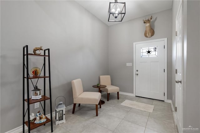 foyer with a chandelier, baseboards, and light tile patterned floors