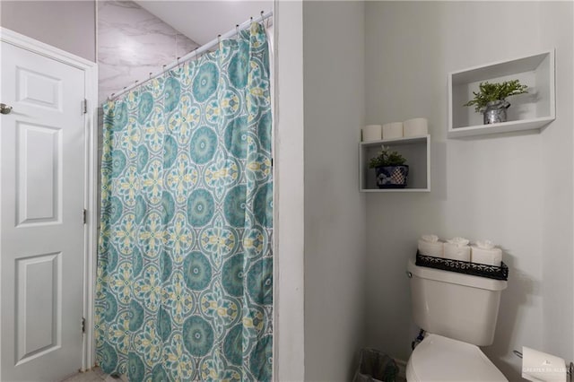 bathroom with a shower with shower curtain and toilet