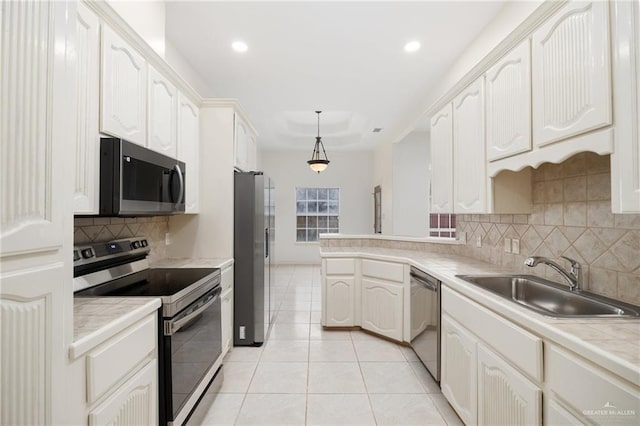 kitchen with a sink, appliances with stainless steel finishes, a peninsula, light tile patterned floors, and decorative backsplash