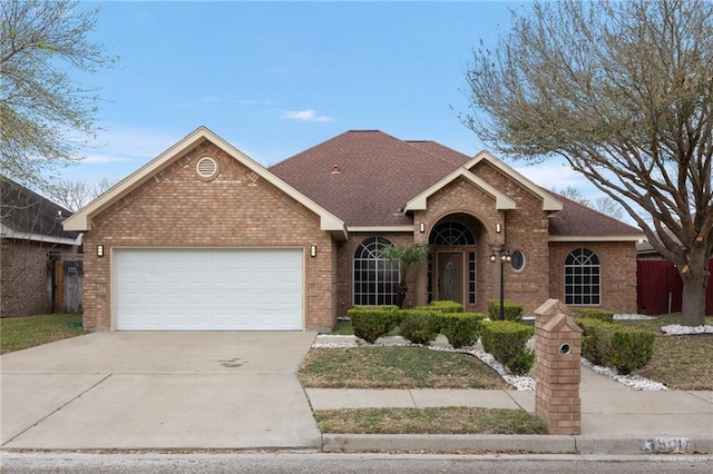 ranch-style home with concrete driveway, brick siding, a garage, and a shingled roof