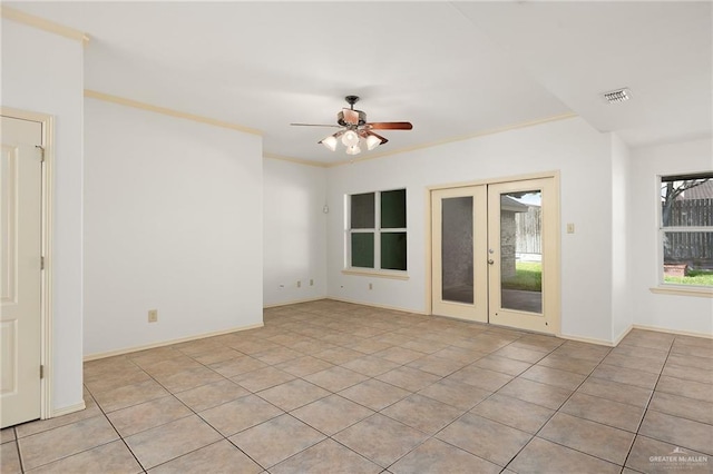 empty room with french doors, light tile patterned floors, ceiling fan, and crown molding