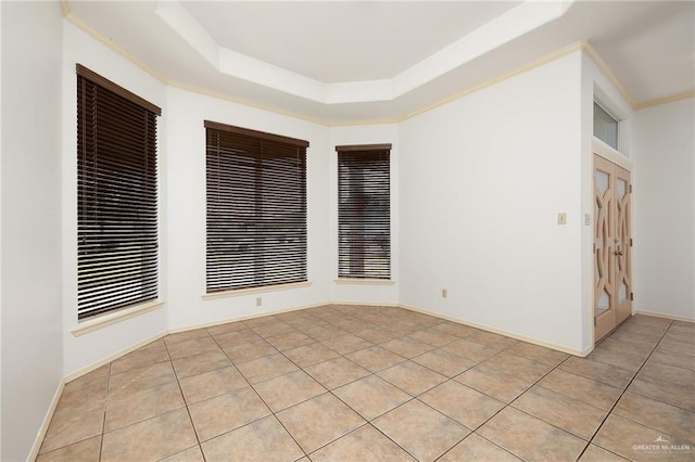 spare room with light tile patterned floors and a tray ceiling