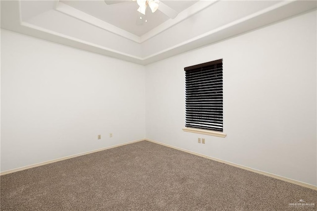 unfurnished room with carpet flooring, a raised ceiling, and ceiling fan