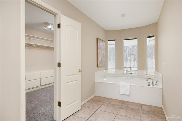 bathroom with tile patterned flooring and a tub to relax in