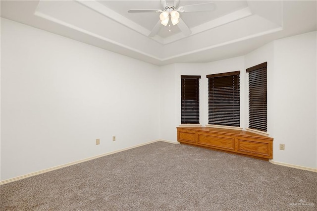 unfurnished bedroom with a raised ceiling, ceiling fan, and carpet flooring