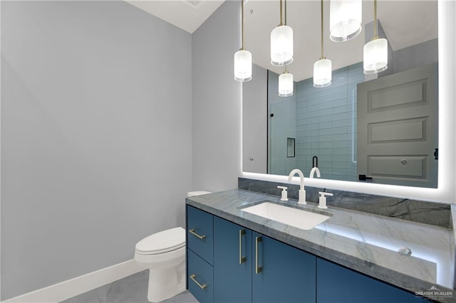 bathroom featuring tile patterned floors, vanity, toilet, and a shower with shower door