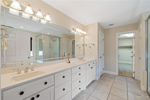 5501 N 1st Ln, Mcallen, TX 78504 - bathroom with a stall shower, tile patterned flooring, baseboards, double vanity, and a spacious closet