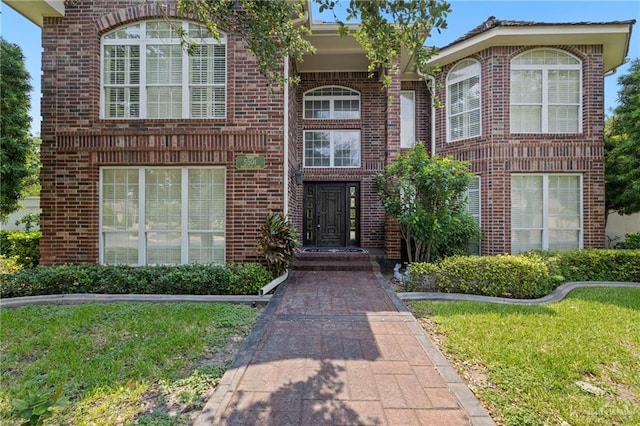 5501 N 1st Ln, Mcallen, TX 78504 - view of exterior entry featuring brick siding and a yard