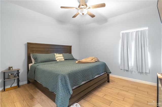 bedroom featuring baseboards, a ceiling fan, and light wood finished floors