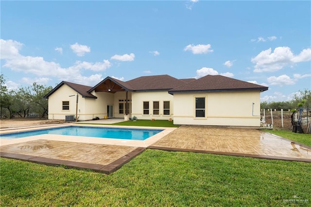 rear view of property with a lawn, central AC, and a patio