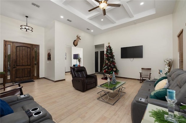 living room featuring a high ceiling, light hardwood / wood-style flooring, ceiling fan, and coffered ceiling