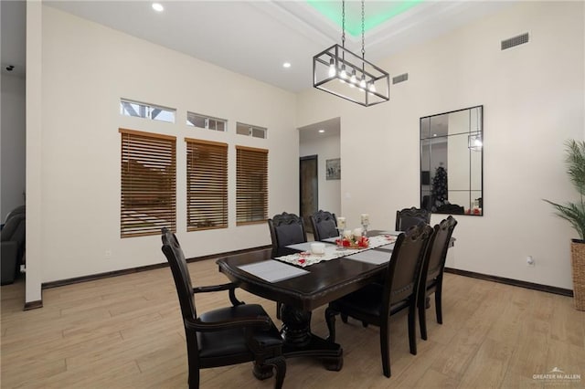 dining room with a high ceiling and light wood-type flooring