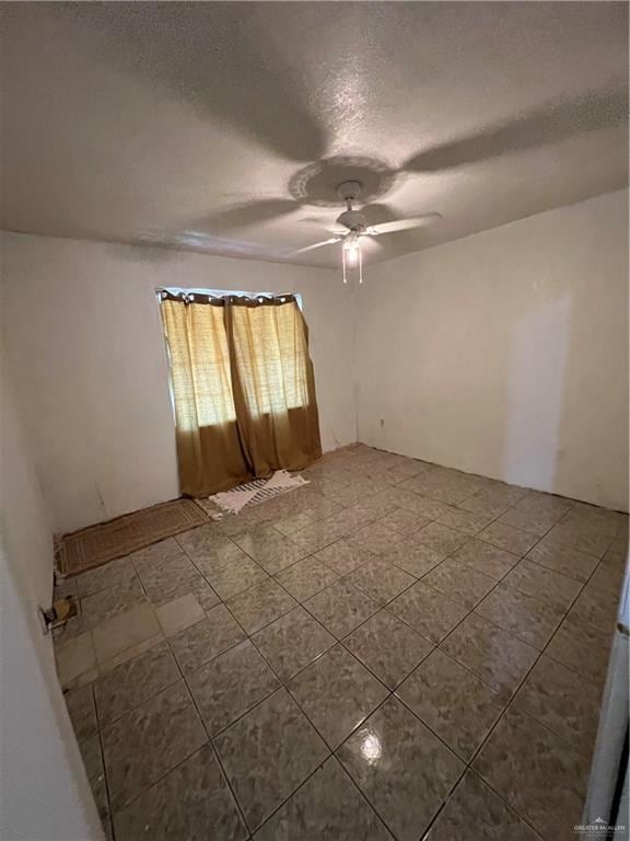 unfurnished room with a textured ceiling and ceiling fan