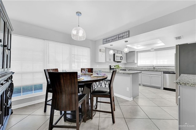 dining room featuring light tile patterned floors, baseboards, a raised ceiling, and visible vents