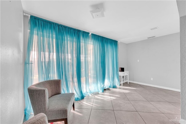 sitting room with visible vents, baseboards, and tile patterned flooring