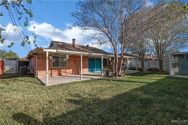 rear view of house featuring brick siding, a fenced backyard, and a patio area