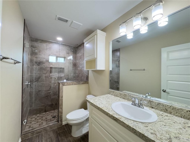 1419 Frente Al Mar Dr, Weslaco, TX 78596 - full bath with a shower stall, wood tiled floor, visible vents, toilet, and vanity