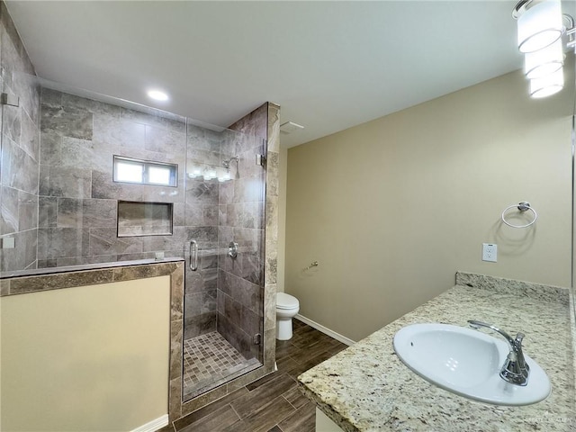 1419 Frente Al Mar Dr, Weslaco, TX 78596 - bathroom with a stall shower, baseboards, toilet, wood finish floors, and vanity