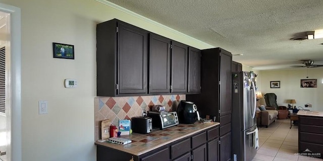 2219 Ella Ave, Harlingen, TX 78550 - kitchen featuring freestanding refrigerator, tile countertops, backsplash, a textured ceiling, and ceiling fan