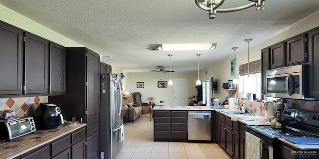 2219 Ella Ave, Harlingen, TX 78550 - kitchen with appliances with stainless steel finishes, a peninsula, light tile patterned floors, tile countertops, and backsplash