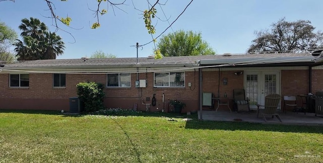 2219 Ella Ave, Harlingen, TX 78550 - rear view of property featuring brick siding, a patio area, a lawn, central air condition unit, and french doors