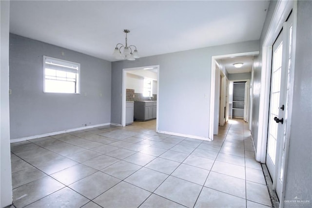 28099 Nelson Rd, San Benito, TX 78586 - unfurnished dining area featuring a chandelier, light tile patterned floors, and baseboards