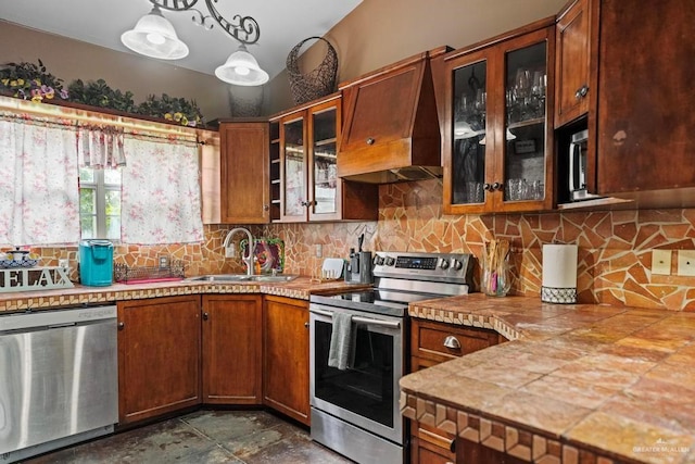 kitchen with sink, hanging light fixtures, stainless steel appliances, premium range hood, and decorative backsplash