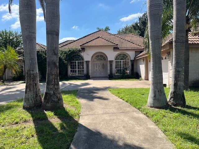 view of front of house with a garage and a front lawn