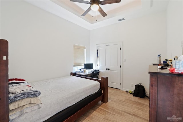 13801 N 37th St, Mcallen, TX 78504 - bedroom featuring a tray ceiling, light wood finished floors, a ceiling fan, and a high ceiling