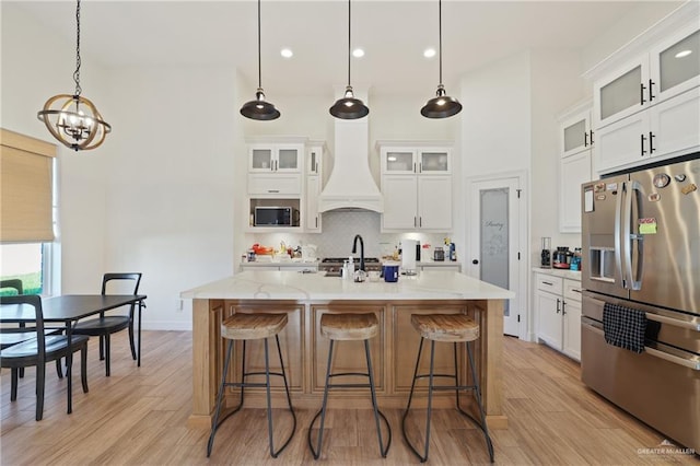 13801 N 37th St, Mcallen, TX 78504 - kitchen featuring appliances with stainless steel finishes, custom exhaust hood, a chandelier, a kitchen bar, and tasteful backsplash