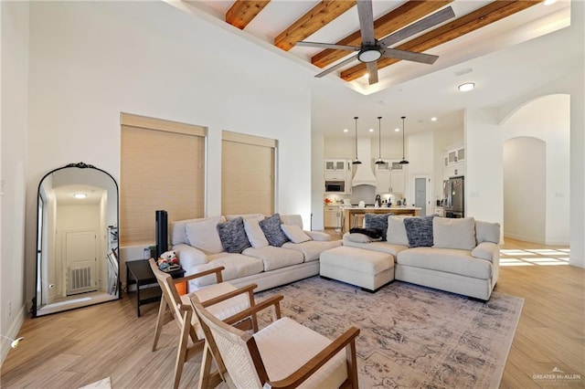 13801 N 37th St, Mcallen, TX 78504 - living area with a towering ceiling, arched walkways, a ceiling fan, beamed ceiling, and light wood-style floors