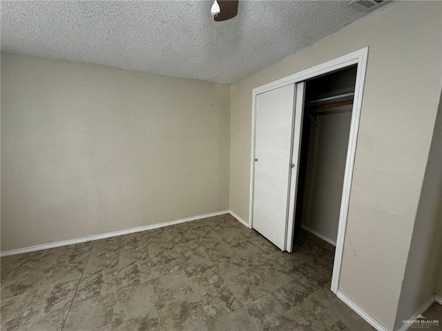 unfurnished bedroom with a textured ceiling, a closet, and ceiling fan