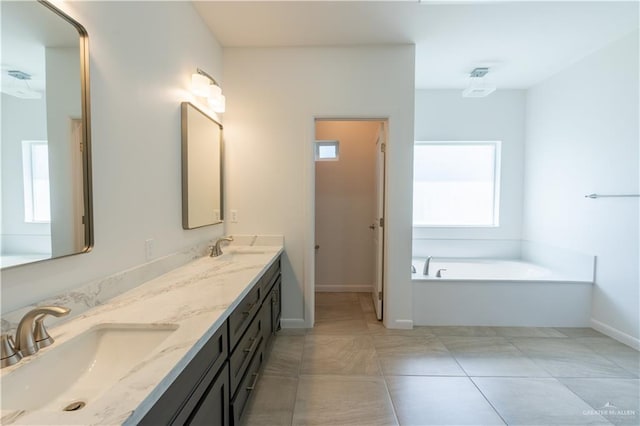 bathroom with plenty of natural light, vanity, a bath, and tile patterned flooring