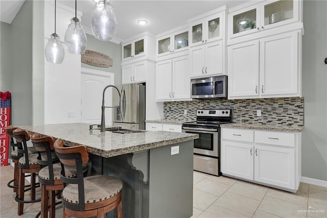 3601 Stratosphere Dr, Edinburg, TX 78539 - kitchen with appliances with stainless steel finishes, backsplash, light stone countertops, and a kitchen breakfast bar
