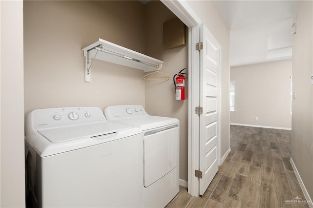 laundry room with baseboards, laundry area, wood finished floors, and washer and dryer